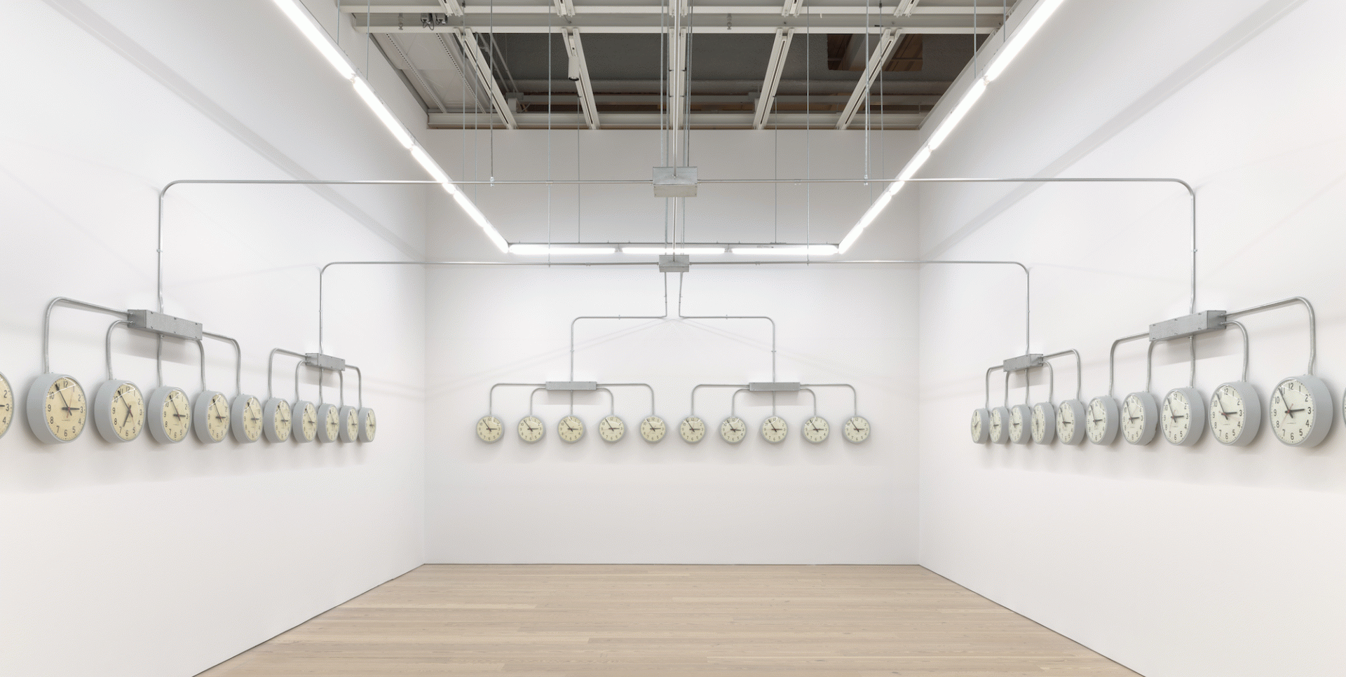 Agustina Woodgate, National Times, 2019, Site specific infrastructure: Closed circuit of 40 analog clocks, 1 digital master clock, sanding blocks, and electrical metal tubing. 2019 Whitney Biennial, Whitney Museum of American Art. Curators: Jane Paneta and Rujeko Hockley